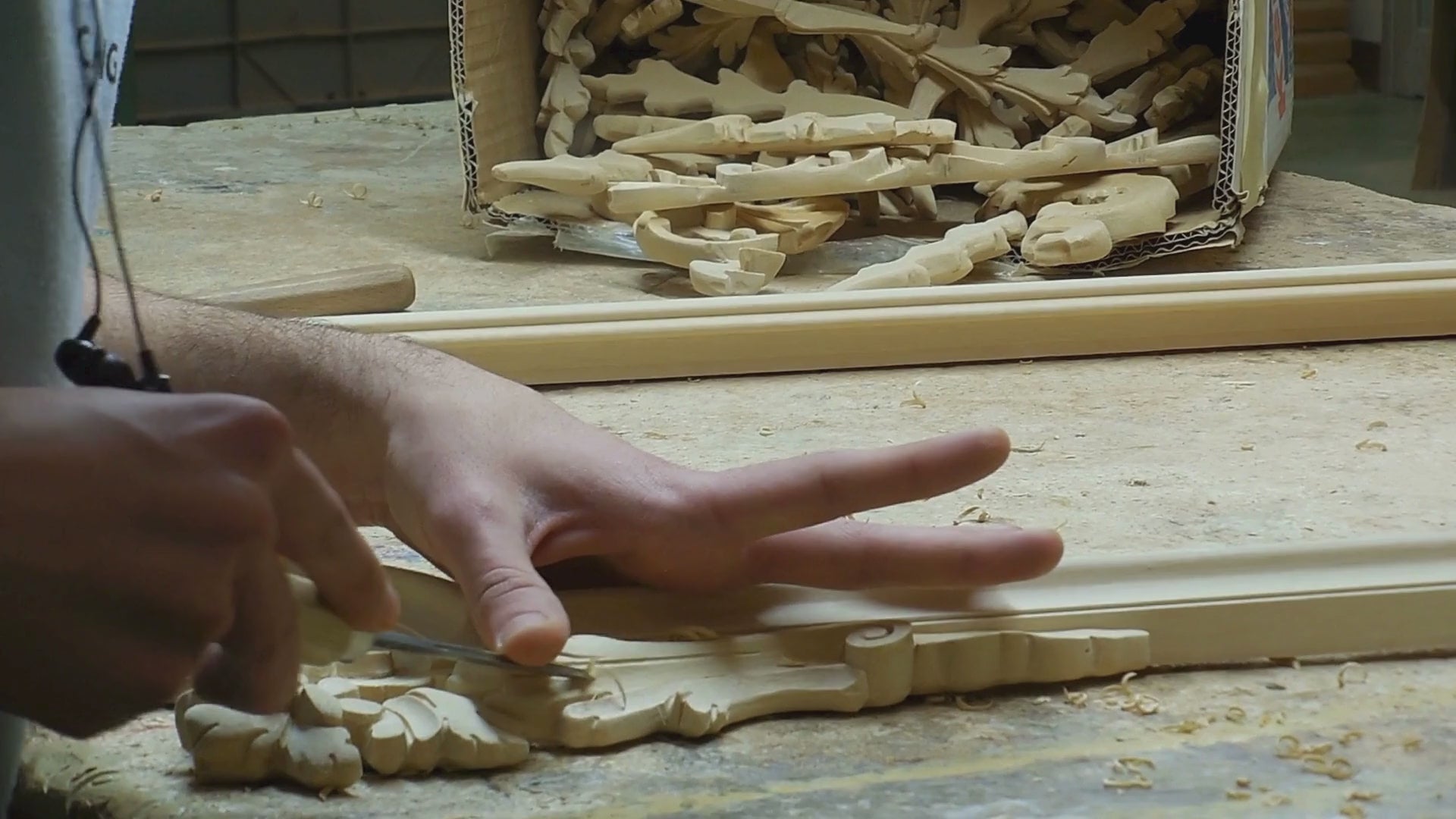 Load video: Artisan carving a wooden mirror frame by hand in Italy.