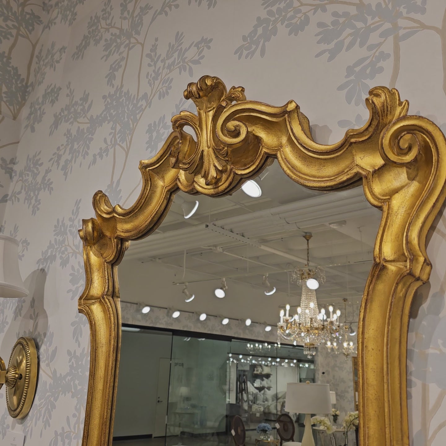Ornate gold Italian mirror in luxury showroom.