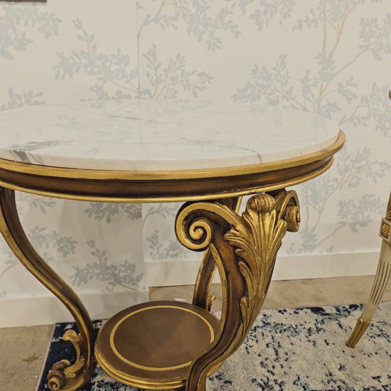 Ornate carved wood Italian table with gold details and white marble top.