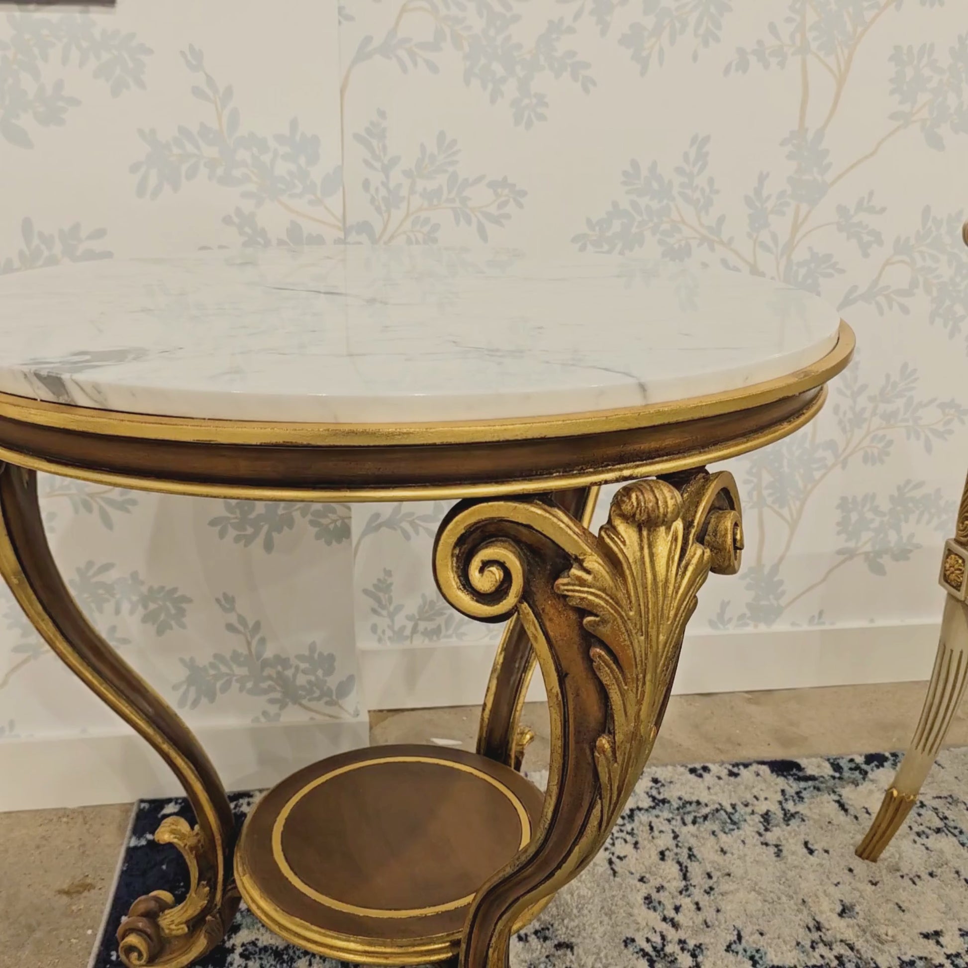 Ornate carved wood Italian table with gold details and white marble top.