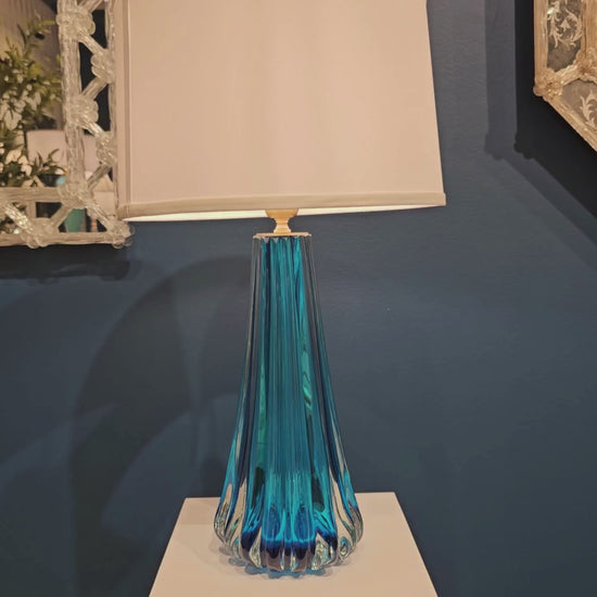 Blue Murano glass table lamp with white lamp shade.