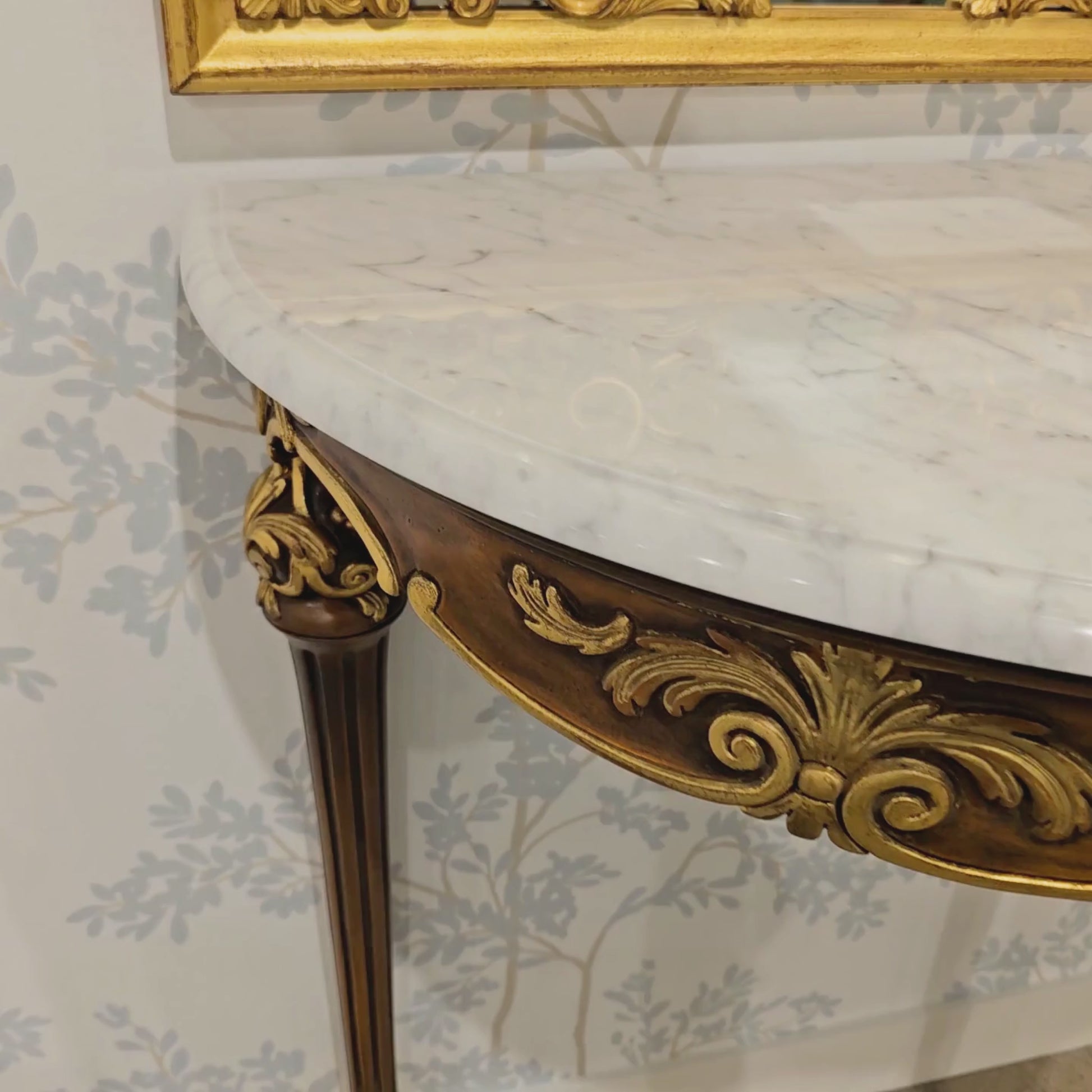 Ornate brown and gold Italian console with white marble top.