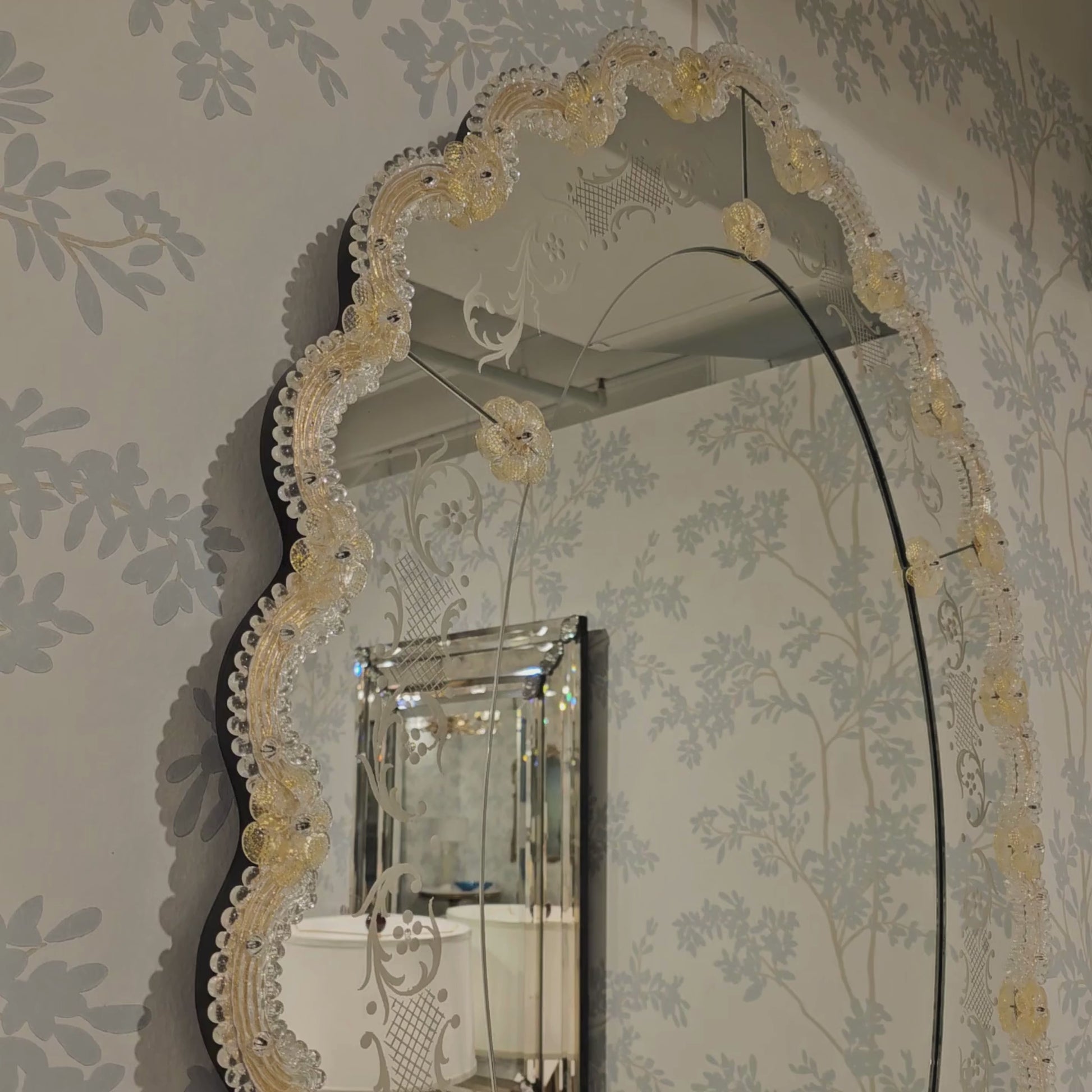 Ornate gold Venetian glass mirror in luxury showroom.