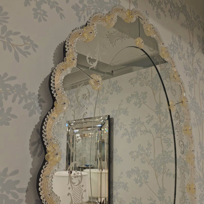 Ornate gold Venetian glass mirror in luxury showroom.