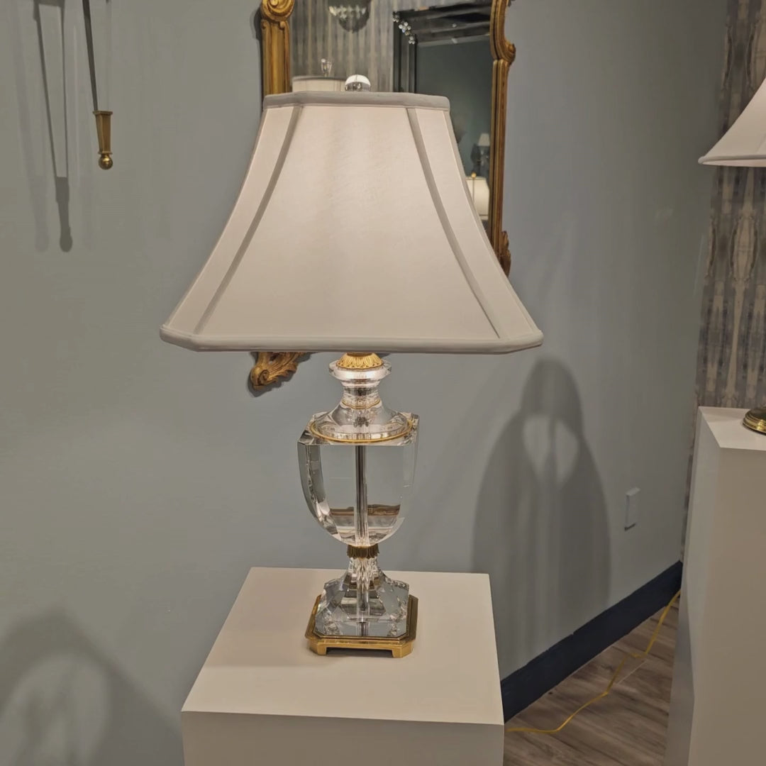 Crystal and brass table lamp with white shade.