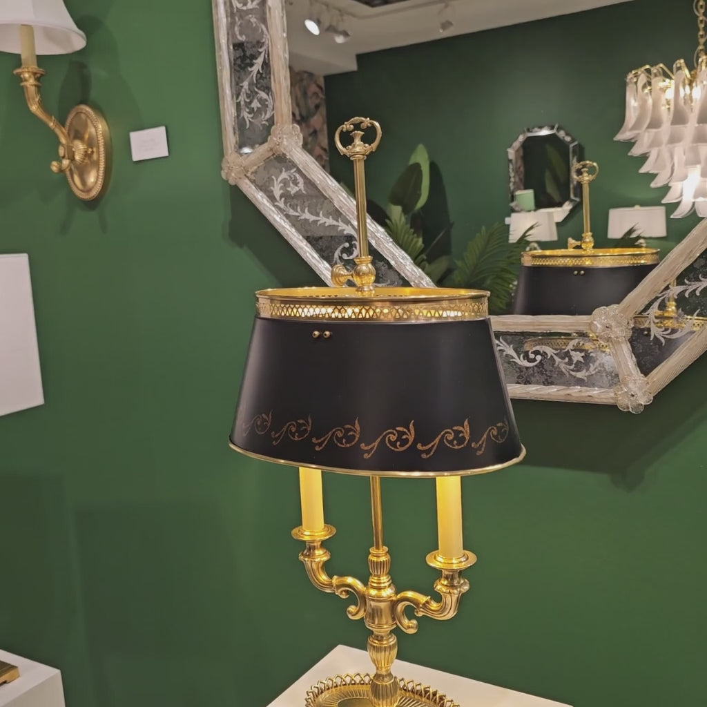 Antique brass bouillotte table lamp with black shade.
