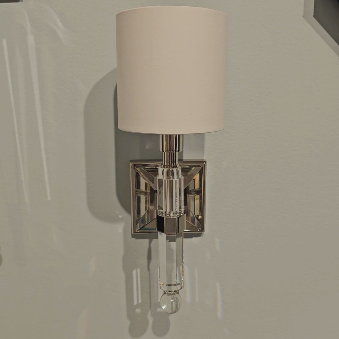 Polished nickel and crystal sconce with white shade.