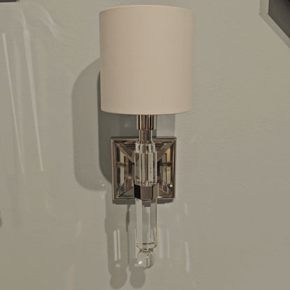 Polished nickel and crystal sconce with white shade.