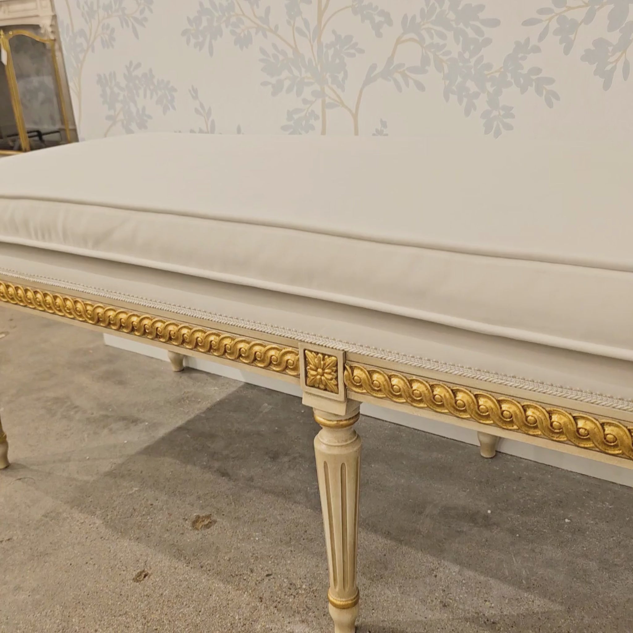 A white and gold Italian bench.
