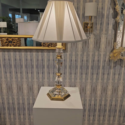 Crystal and brass table lamp with white pleated shade.
