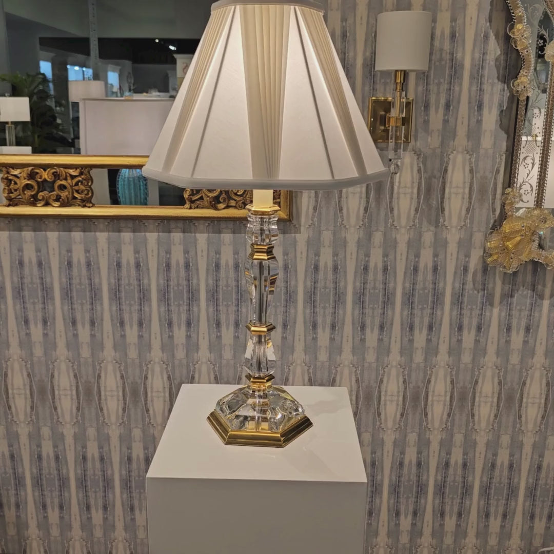 Crystal and brass table lamp with white pleated shade.