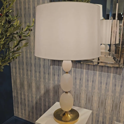 Brass and alabaster table lamp with white lamp shade.