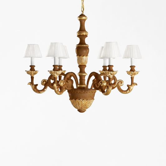 Traditional wood chandelier with gold details and white pleated shades.
