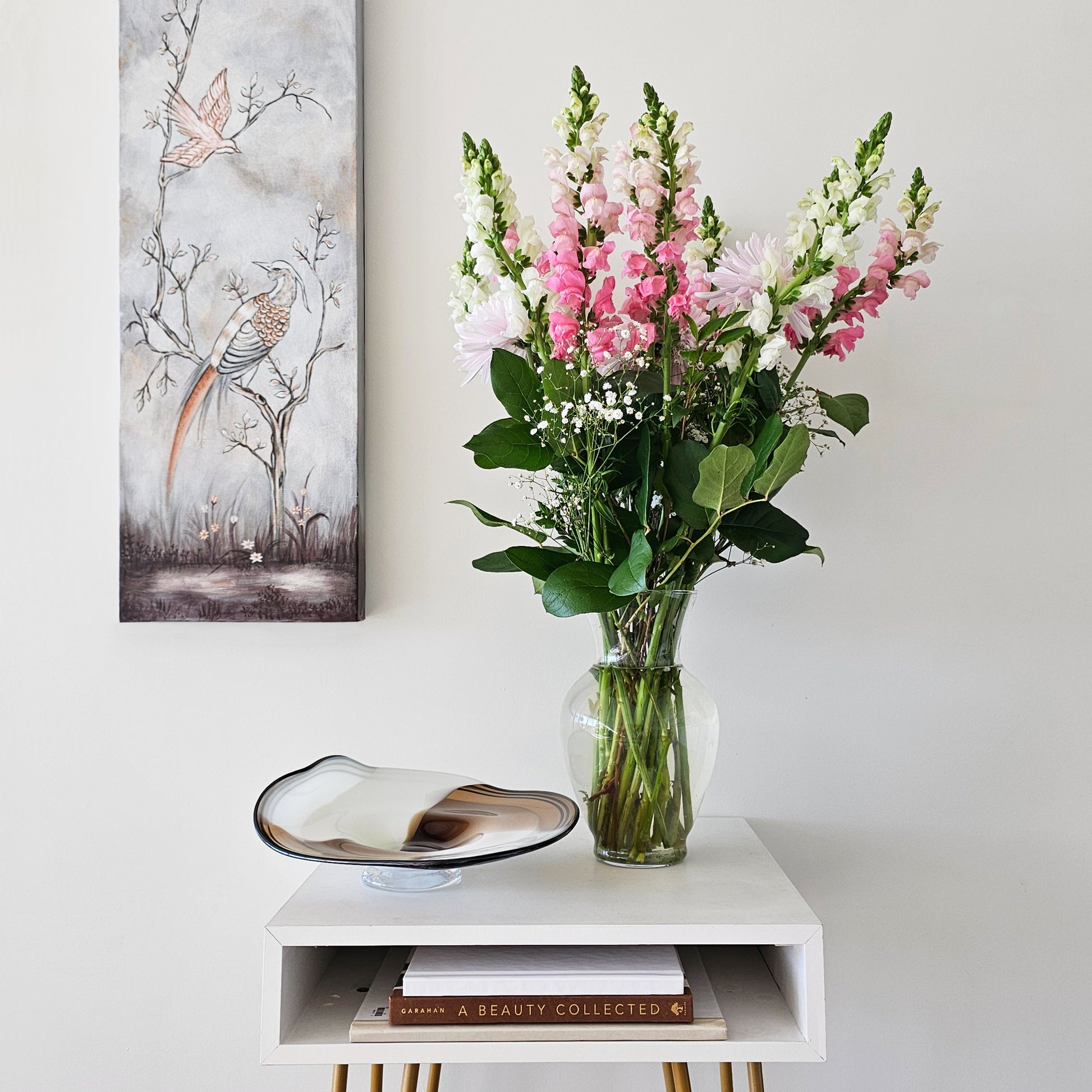 Silver wall panel and brown glass bowl.