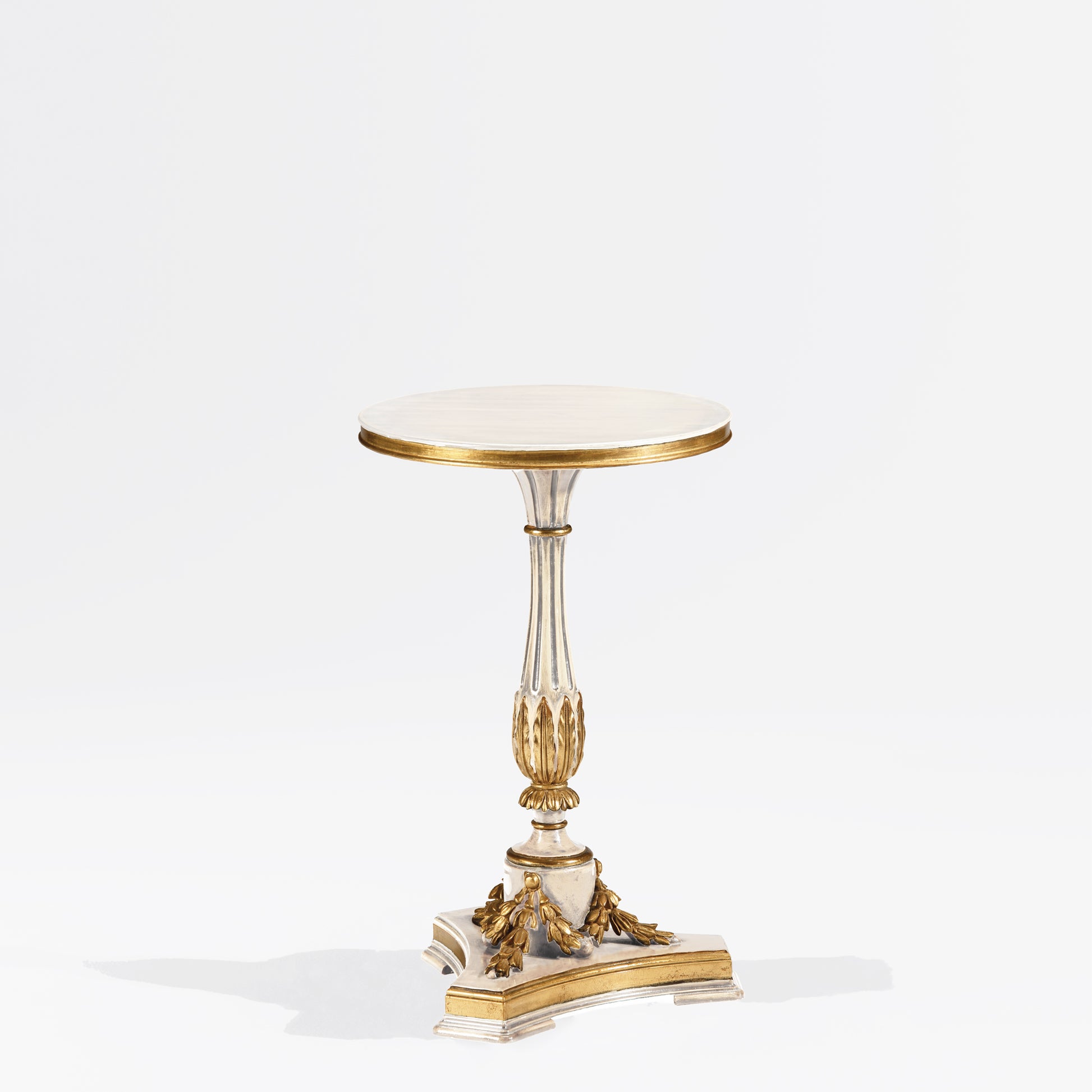 White accent table with gold leaf trim.
