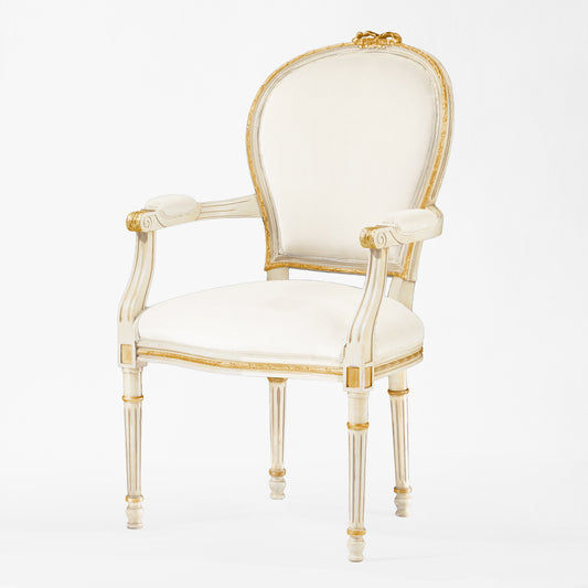 Antique white and gold armchair with cream fabric.